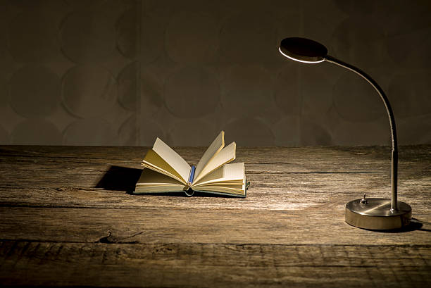 Open paperback book with warm lamp light for evening reading